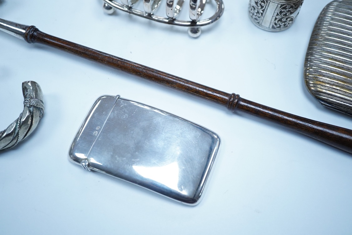 A group of assorted silver, to include a pair of modern five bar toast racks, a George V card case, a sterling vesta case, four assorted condiments, two mounted toilet bottles, mounted timepiece, a modern wooden handled